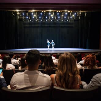 People at a theater looking at a dress rehearsal of ballet performing arts