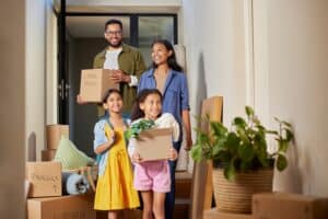 A happy family moves into a new luxury high-rise apartment, with smiling parents and children carrying boxes together on moving day