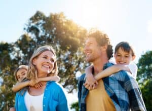 Happy family enjoying outdoor piggyback ride in nature, bonding together on summer walk in Hartford CT