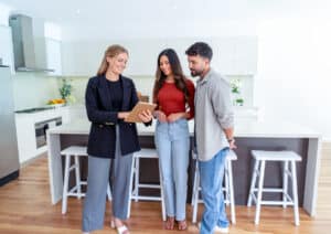 Prospective renters touring a modern apartment kitchen with a leasing agent.